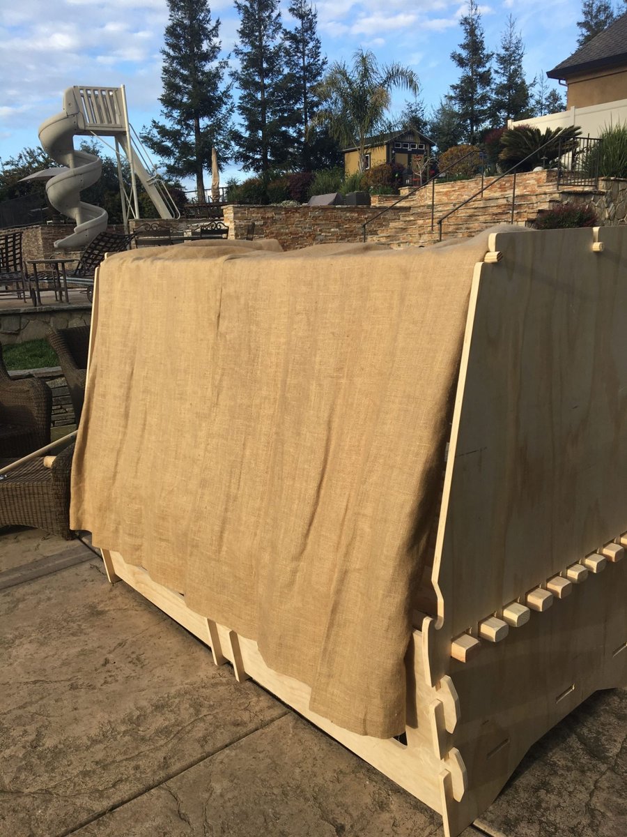 COVE bed pod with a burlap privacy canopy, showing wedge-and-peg joinery
