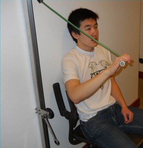 Demonstrating the Cranken wall-mounted exercise apparatus with a resistance band