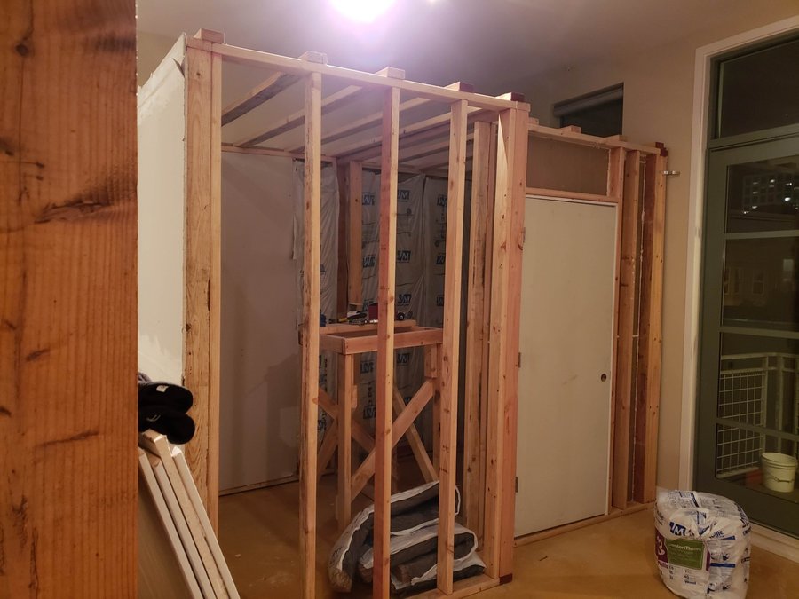 Stud framing of the cube rooms going up inside the loft, with insulation staged