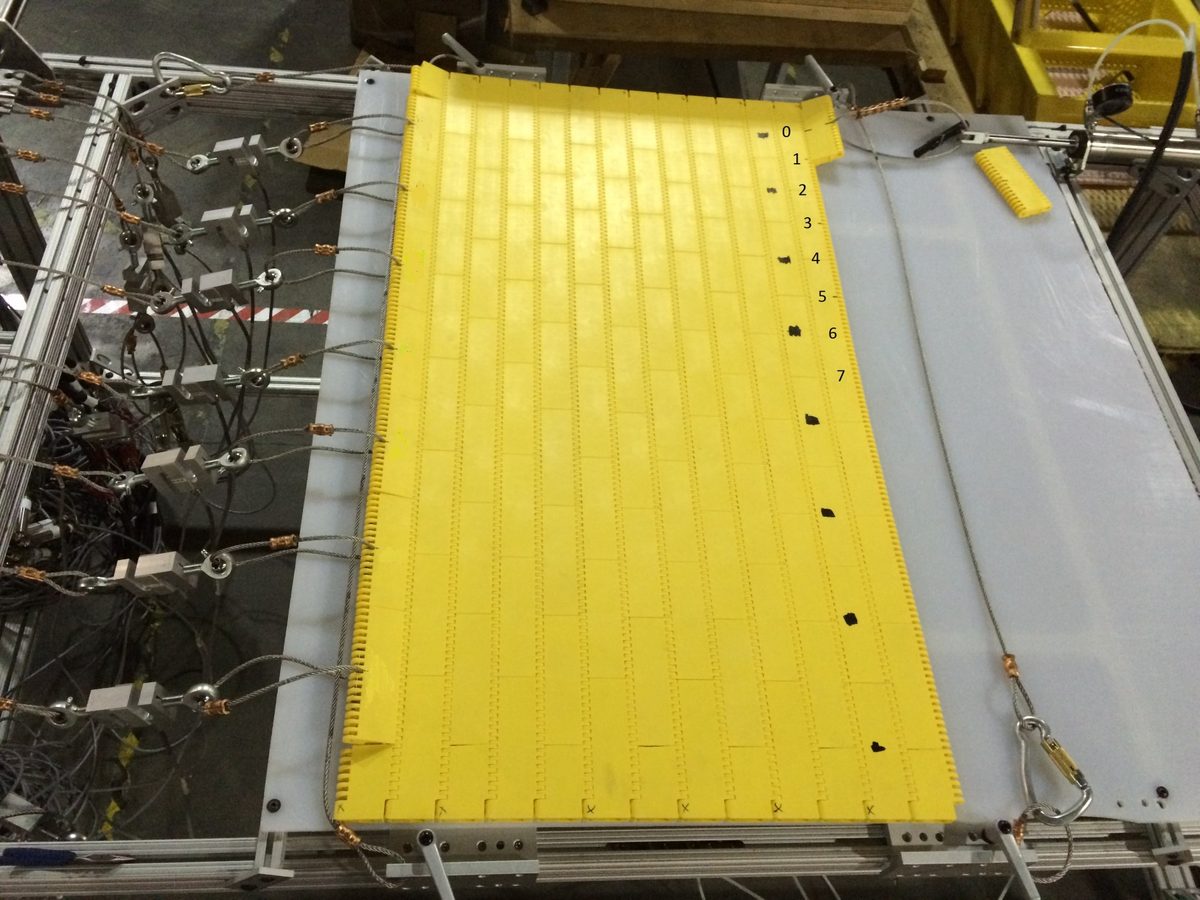 Test table with a yellow modular conveyor belt instrumented with load cells